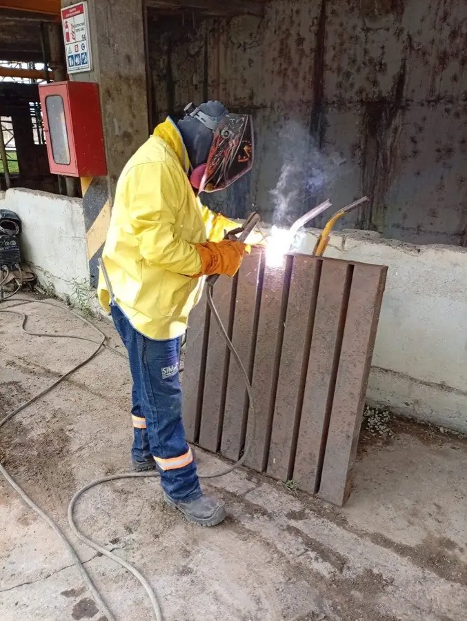Soldador certificado de SIMA ejecutando soldadura revestida sobre lámina en taller