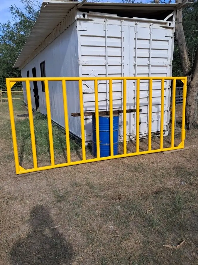 Cerco industrial metálico pintado en amarillo de seguridad, instalado por SIMA